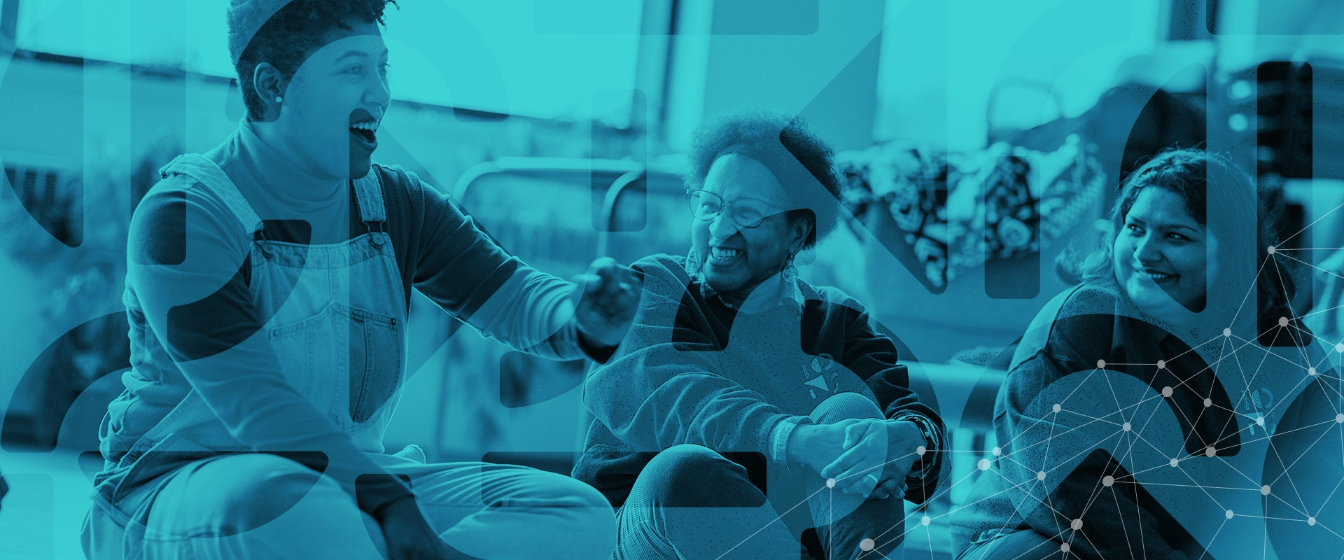 A photo of the IONS 2023-2024 Impact Report- two people laughing while sitting down.